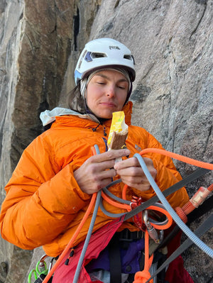 Ambassadör som utför bergskläddring använder Moonvalley veganska energibar som en vikig energikälla