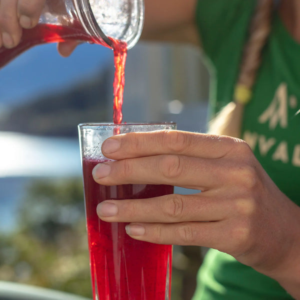 Ekologisk sportdryck pulver - Ida Nilsson häller upp en av Moonvalleys sportdryckspulver - Lingonberry 