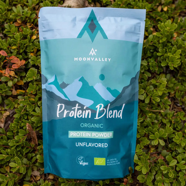 Moonvalley ekologiskt proteinpulver utan smak i återförslutningsbar påse, fotograferat i naturlig utomhusmiljö.