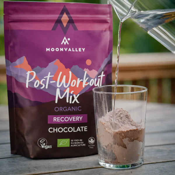 Ett glas med Moonvalley Post-Workout Mix blandas med vatten.